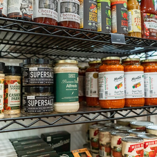 Shelves at Newbury Deli filled with various sauces, spices, and canned goods.