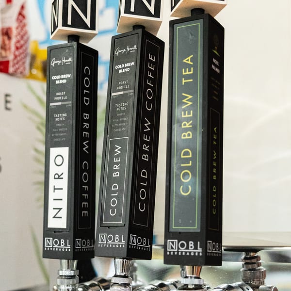 Three Newbury Deli cold brew coffee and tea taps with detailed descriptions of each blend.