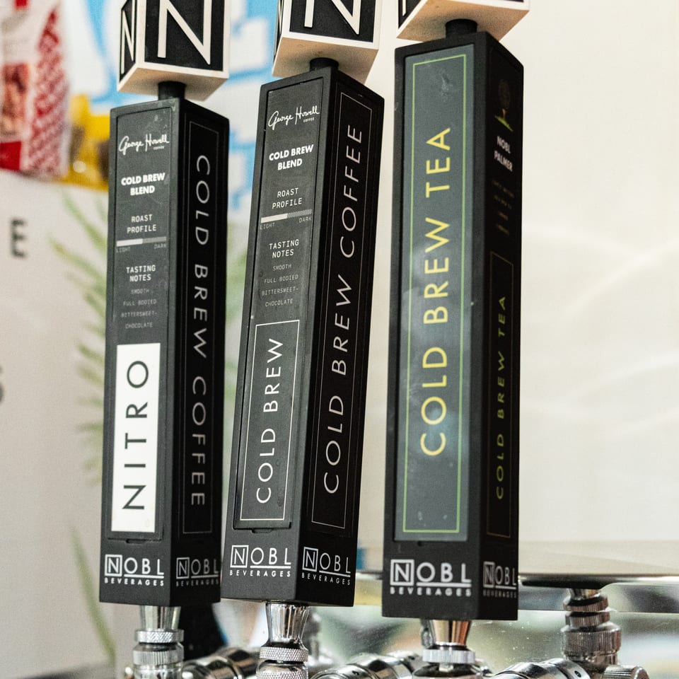 Three Newbury Deli cold brew coffee and tea taps with detailed descriptions of each blend.
